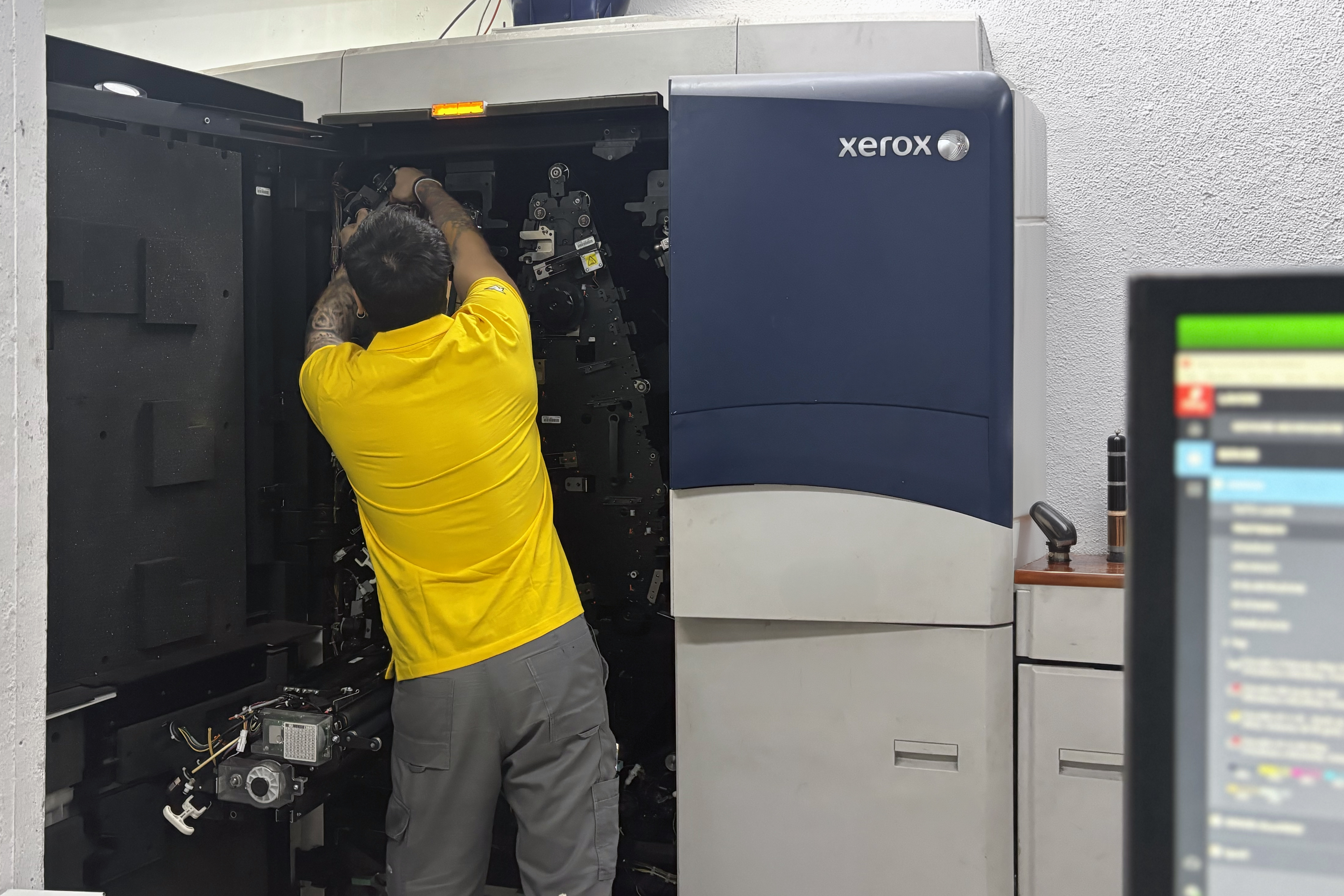 Professional technicians maintaining Xerox digital printing equipment for book production. Sprint24.