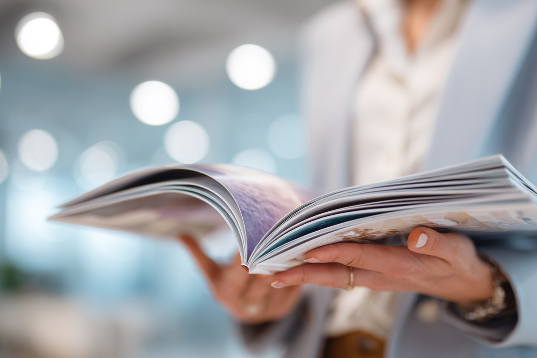 High-quality printed book with vibrant colour pages held open in hands premium publications. Sprint24.