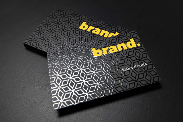 These professional business cards feature a striking embossed geometric pattern with bright UV spot coating that creates a glossy relief effect. The premium laminated finish with UV gloss combines high-quality craftsmanship with elegant design for memorable brand impressions. These UV-coated laminated cards demonstrate Sprint24's expertise in premium business card printing.