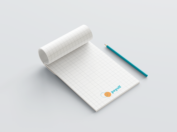 An open custom A5 notepad with a 10mm grid template featuring the Payoff brand logo at the bottom corner, displayed with a teal pencil on a white background. Custom A5 notepads with printed templates — millimetred, dotted, squared or lined — are ideal promotional tools for companies, agencies and professionals to distribute at meetings, events and trade fairs.