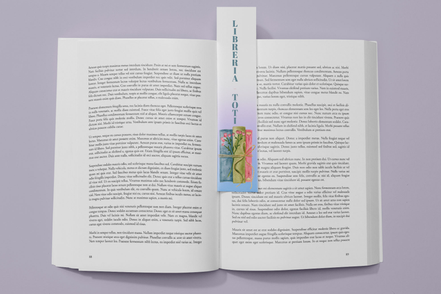 An open hardcover book with a tall illustrated custom bookmark featuring decorative graphics and vertical text inserted between the pages. Sprint24 prints custom bookmarks with full personalisation: shape, size, lamination and glossy details — perfect as promotional gadgets, press kit inserts and bookshop or library giveaways.