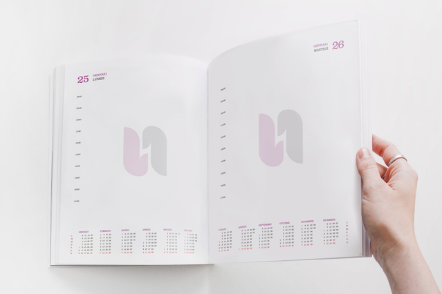 Hand holding open thread-sewn daily agenda pink U logo watermark and. Hand holding open thread-sewn daily agenda with pink U logo watermark and monthly mini-calendars. 336 pages Sprint24.