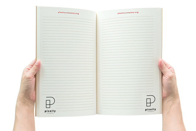 Two hands holding open a branded paperback notebook for 'Pixelly Company' with lined inner pages, the company logo and website URL printed in the footer of each page. Sprint24 prints custom paperback notebooks in A4 and A5 formats with 32 to 128 sheets — ideal for corporate stationery, employee gifts, conference press kits and branded marketing gadgets.