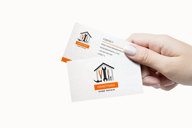 Professional handyman business cards with striking orange branding and home repair design. Printed mockup showcasing custom contact cards for construction and home service professionals. Order high-quality business cards for your handyman or construction business with Sprint24 online printing.