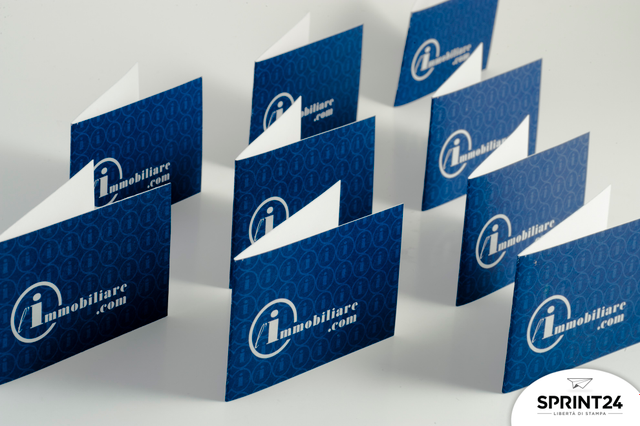 Navy blue folded business cards with white interior detail, perfect for professional double-fold designs. The elegant L'Immobiliare branding on premium cardstock provides twice the space for contact information. Ideal for businesses seeking memorable, sophisticated folded card solutions.