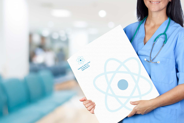 A smiling nurse in blue scrubs holding a large white branded medical report envelope with a blue atom logo in a bright hospital hallway. Sprint24 prints custom x-ray report envelopes and medical bag envelopes for doctors' offices, clinics and hospitals — ideal for delivering patient exams and radiographs in professional, branded packaging.
