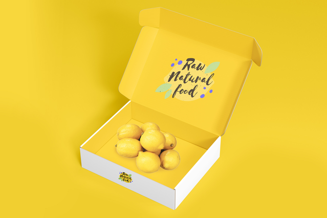 An open self-assembling yellow and white box for 'Raw Natural Food' with playful hand-lettered branding on the inside lid, filled with fresh lemons on a vibrant yellow background. These custom-printed self-assembling boxes are ideal for food brands, organic shops and e-commerce businesses seeking personalised packaging that arrives flat, assembles instantly and makes a memorable unboxing experien…