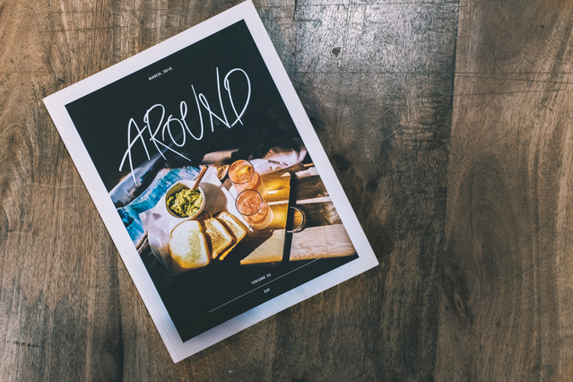 A printed advertising flyer for 'Around' magazine featuring a food photography cover with bold handwritten typography on a wooden surface. Custom advertising flyers are a high-impact printed marketing tool ideal for food brands, restaurants, magazines, events and product launches — printable on both sides for maximum message impact at low cost.