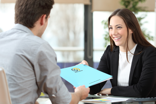 This image showcases a professional using a custom blue A4 folder with pocket to deliver materials during a business meeting, demonstrating how quality printed folders enhance your company's credibility with clients. A4 folders with pockets are ideal for presentations, proposals, and corporate communications that require a polished, organized presentation. Create a lasting impression with profess…