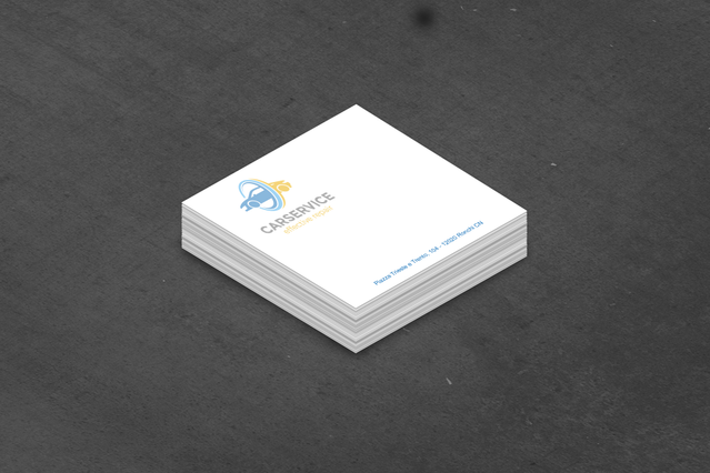 A square paper cube note block with a company logo printed on the top sheet, photographed on a dark stone surface. Sprint24 prints personalised paper cubes of 500 sheets ideal for office use, corporate gifting and brand promotion — available with your logo and custom colours.