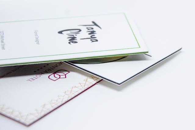 Premium paired business cards stacked and fanned to showcase multi-layer thickness and luxe construction with colored edge binding. The display demonstrates the high-quality, professional finish of coupled business cards with distinct color options. Sprint24's customizable paired business cards combine durability and elegant design for lasting impressions.