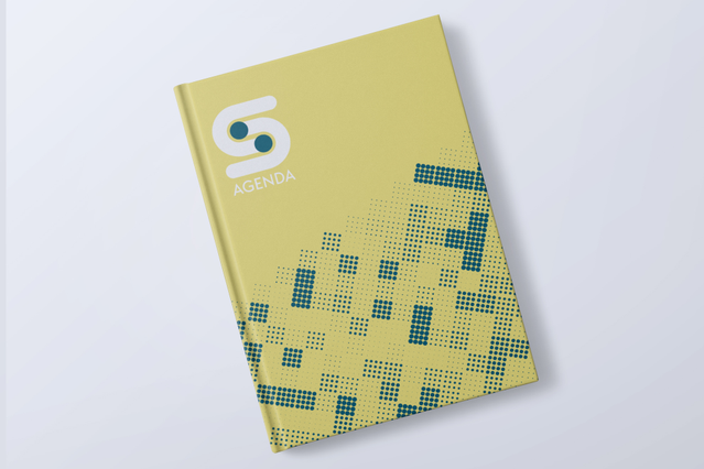 A closed daily hardback agenda with a vivid yellow cover featuring a teal pixel dot mosaic pattern and a white 'S' logo. These custom-printed daily hardback agendas (1 day per page, 2 print formats, fully customisable layout) allow businesses to brand every aspect of the cover and interior — ideal for companies, agencies and professionals seeking elegant personalised daily planners that strengthe…
